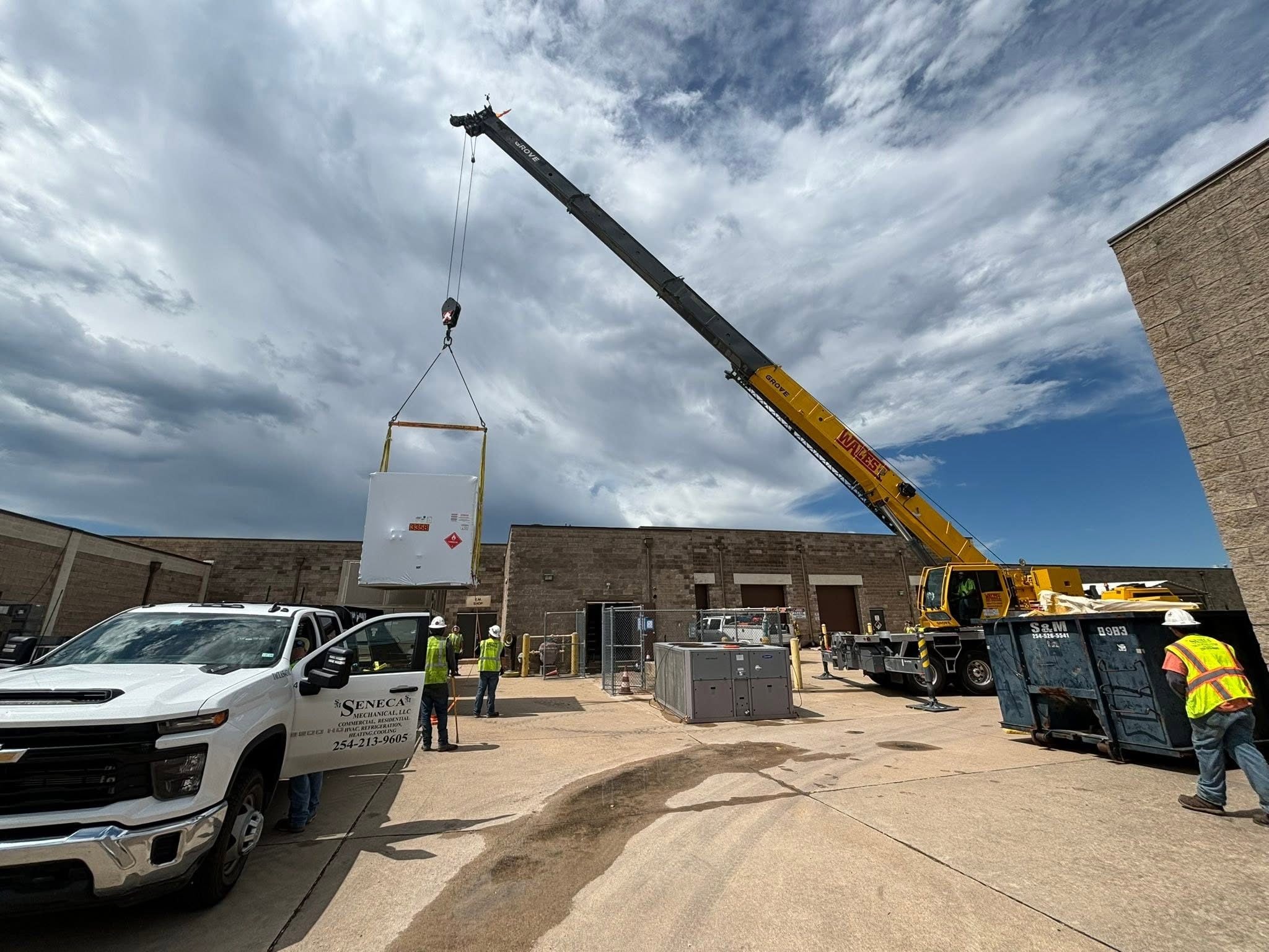 Commercial mechanical equipment being set by crane