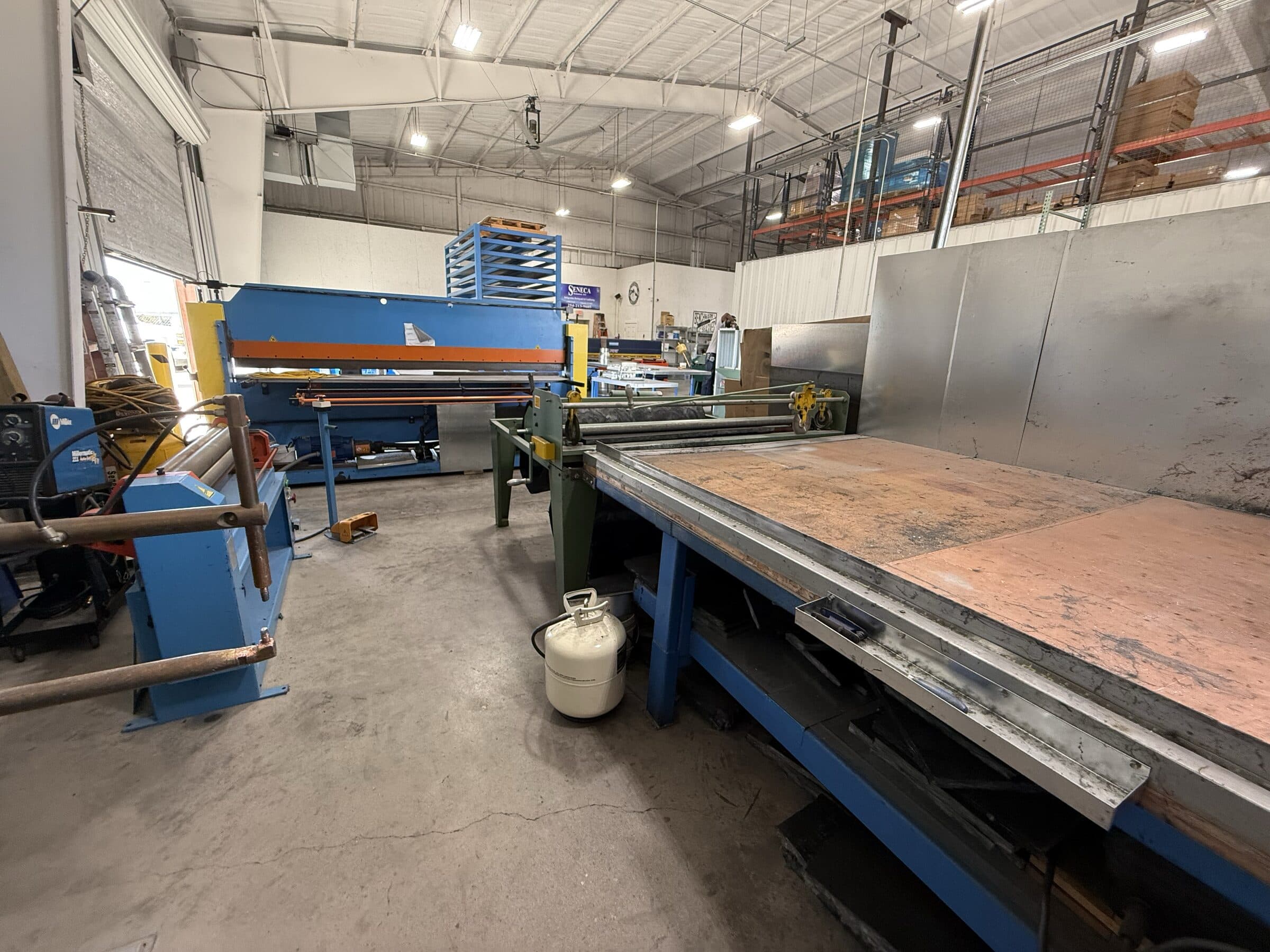 Wide view across the worktables and equipment on Seneca's fabrication shop floor